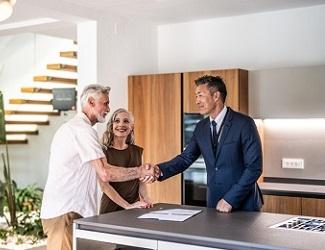 Real estate agent shakes hands with clients