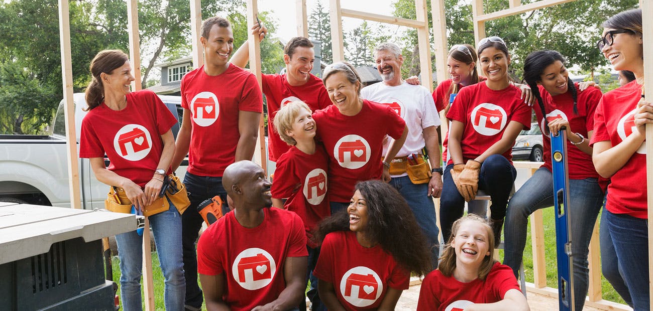 Smiling volunteers at construction frame