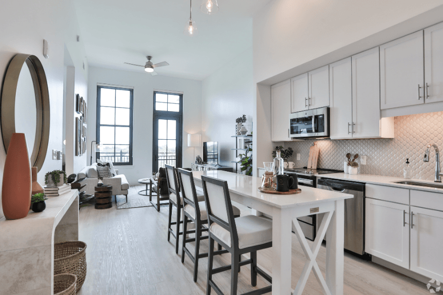 Bright kitchen and sitting area with white countertops and backsplash