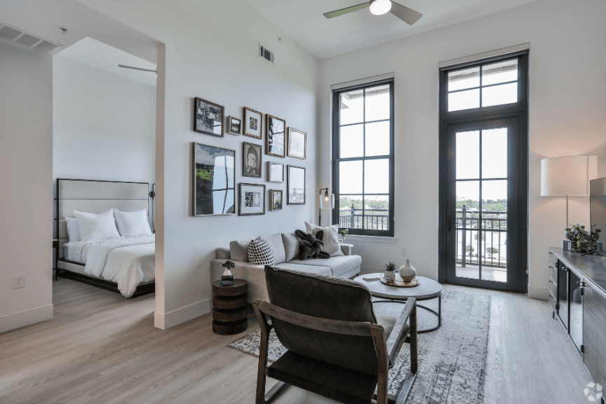 Living room and bedroom in a luxury condo, bright and white with light-color hardwood floors