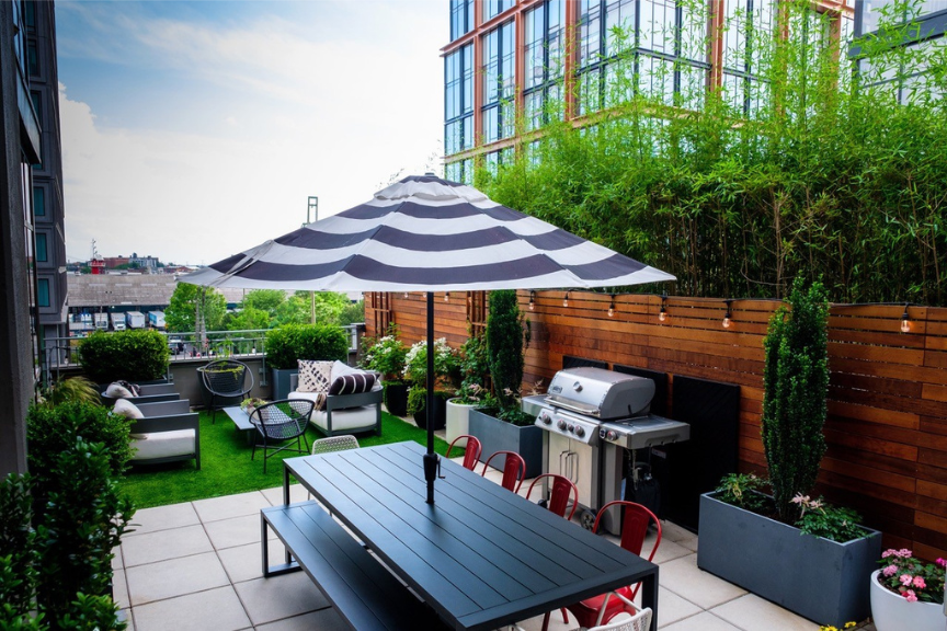 Urban outdoor space with grill, seating area and dark wood picnic table