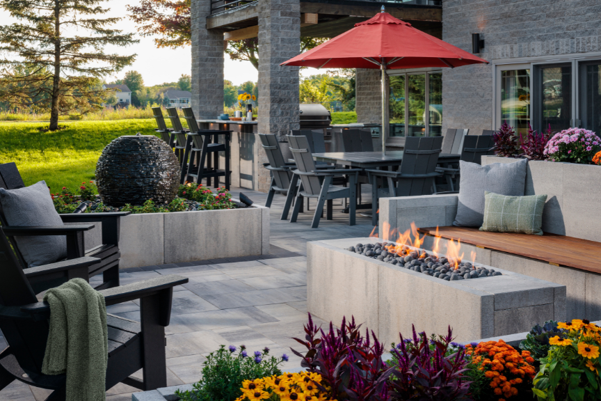 A backyard fire pit surrounded by foliage and seating