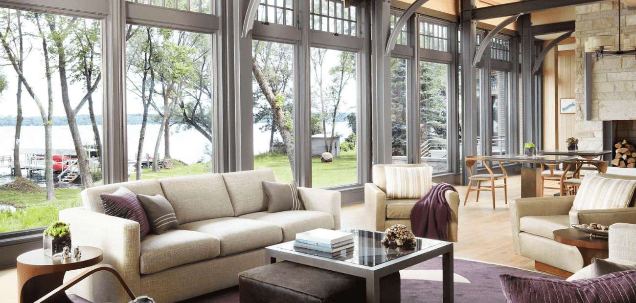 Inside a bright living room with floor-to-ceiling windows overlooking a lake