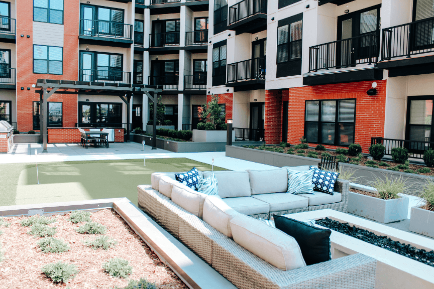 Photo of a recreation deck with seating and a putting green in a multifamily complex