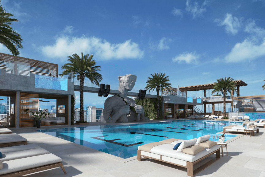 A rooftop pool with plush seating, and a large sculpture of a gray bust