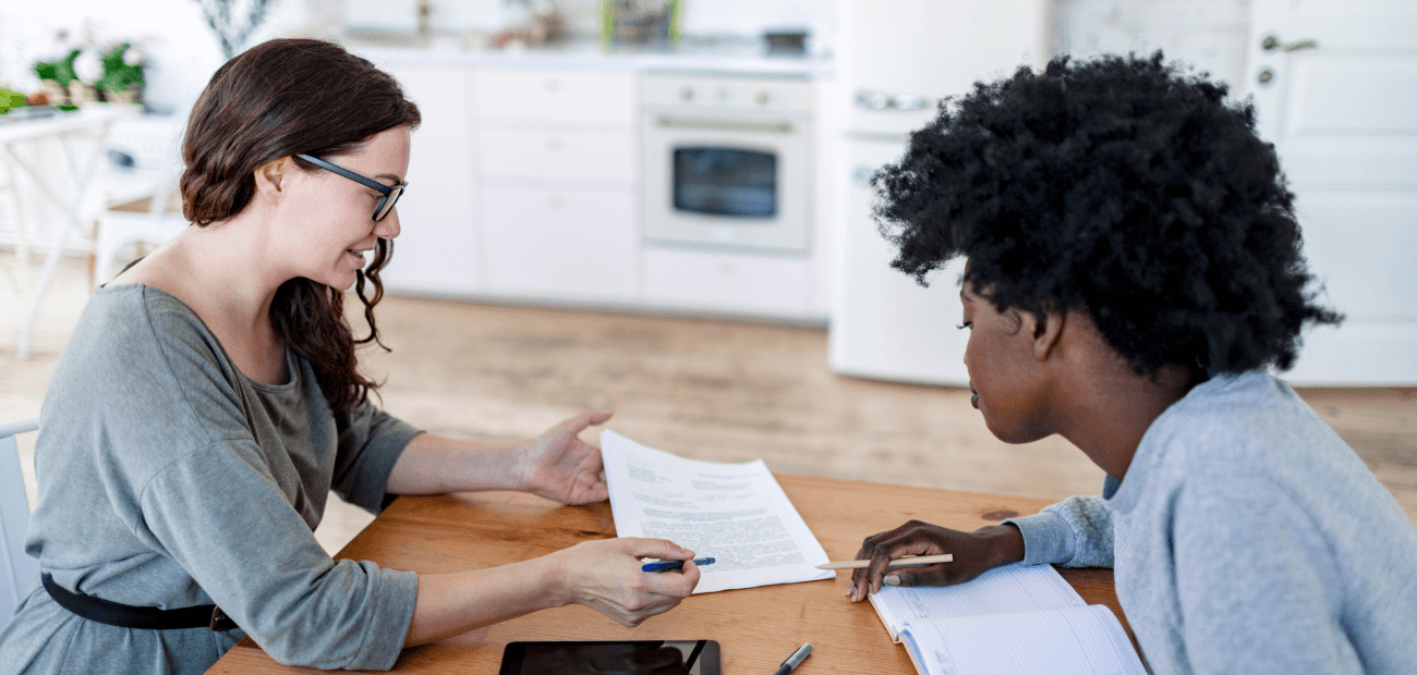 A female-presenting consultant explaining a written agreement to a female-presenting client