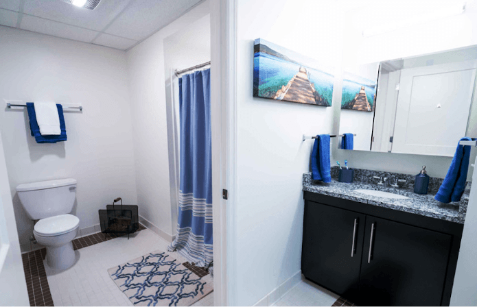 A staged dorm bathroom with blue details.