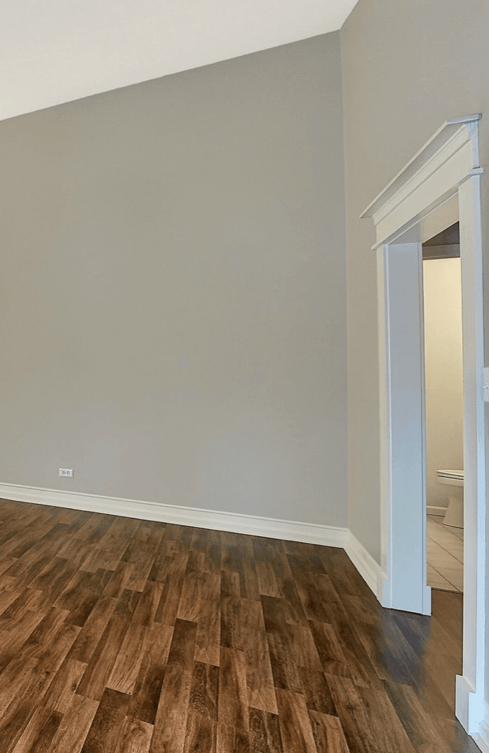 Home interior, grey walls, white trim, wood floors.