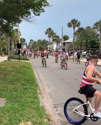 Cyclists and skateboarders sharing First Street in Neptune, FL during the July 4th celebrations