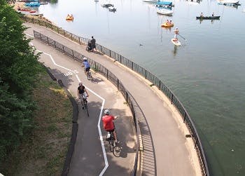 People riding bicycles in bike trail along the water, Minneapolis