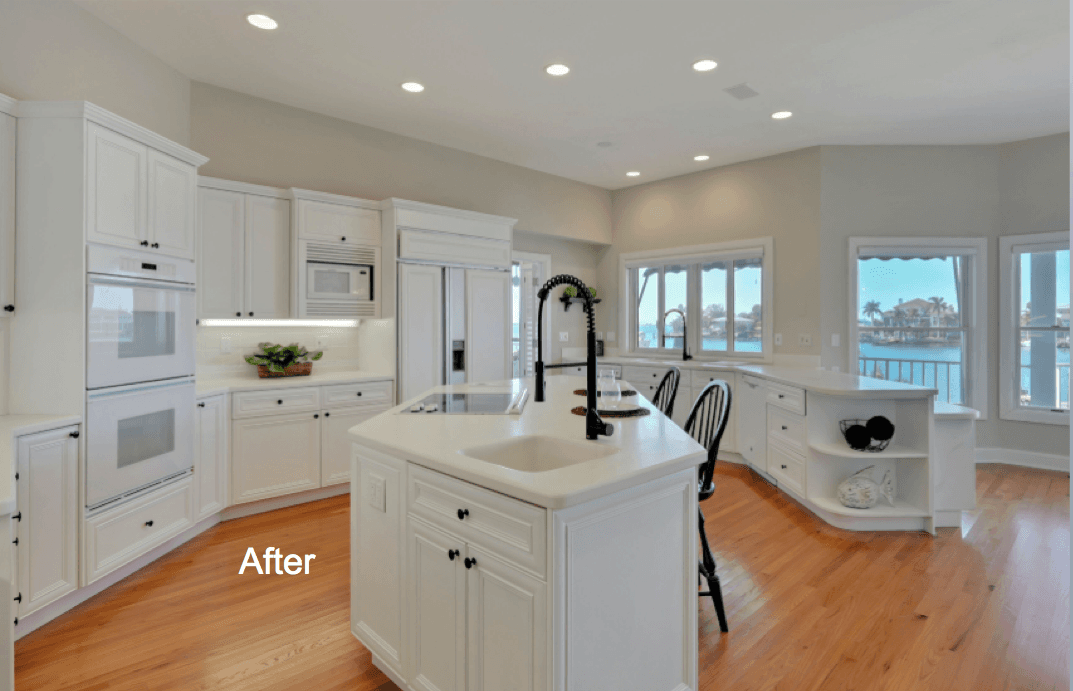 A Kitchen with island, and white cabinets with light colored hardwood floor