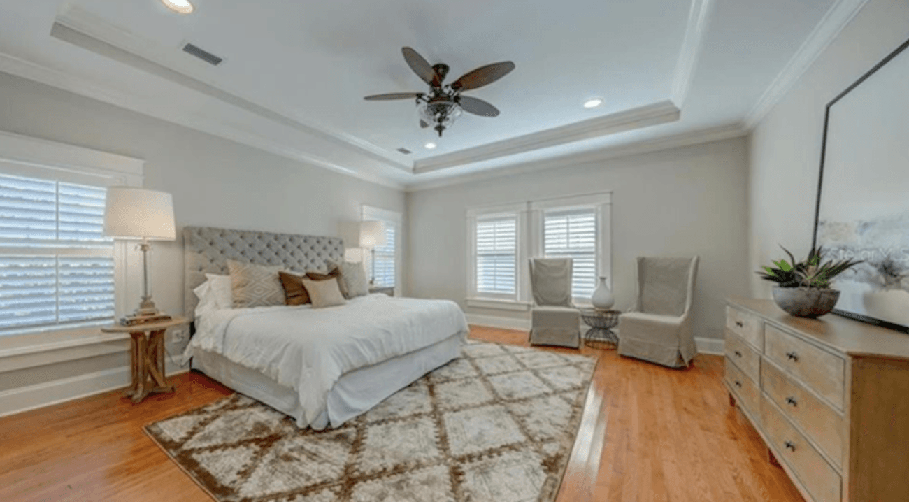 Bedroom with ceiling lights, windows on all sides and floor lamp