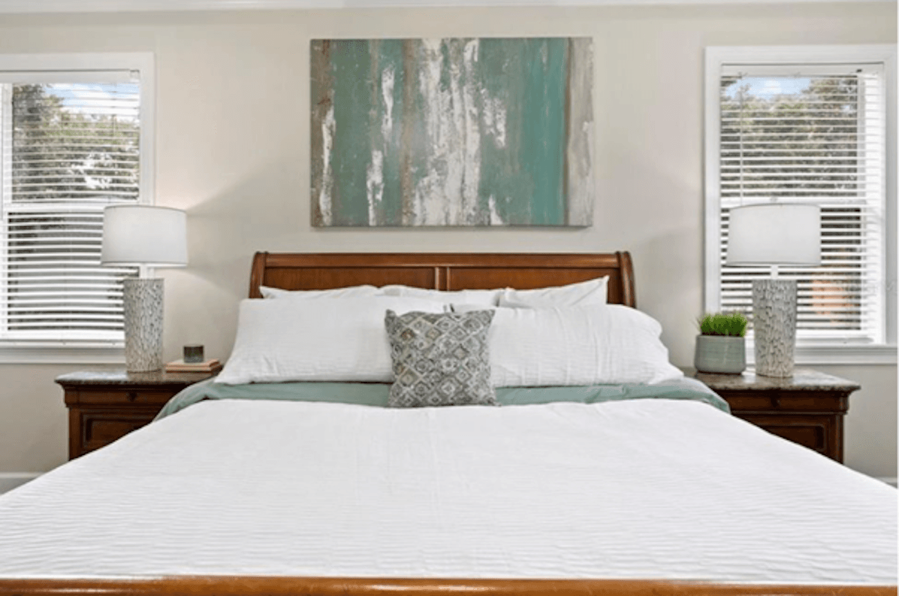 Bed with windows on both sides of the bed and nightstand lamps