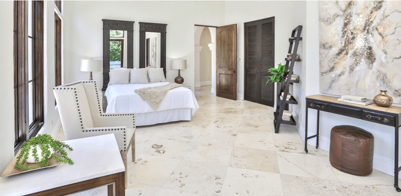 Bedroom with multiple wall mirrors hung up to reflect light