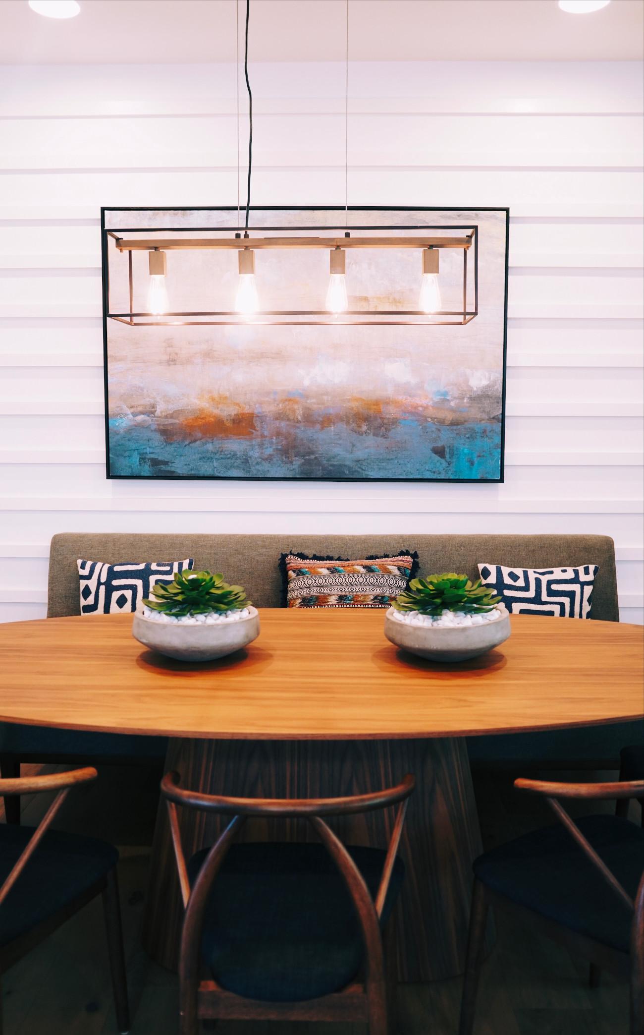 White shiplap wall in a dining room with pendant lamp and wood table