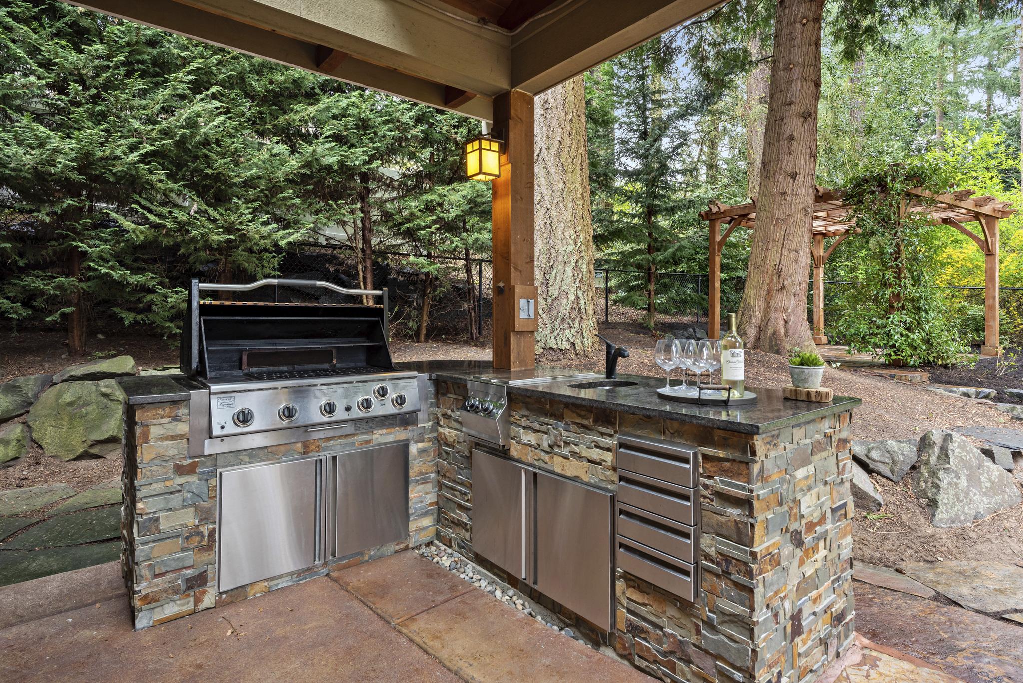 An outdoor barbecue in a wooded back yard.