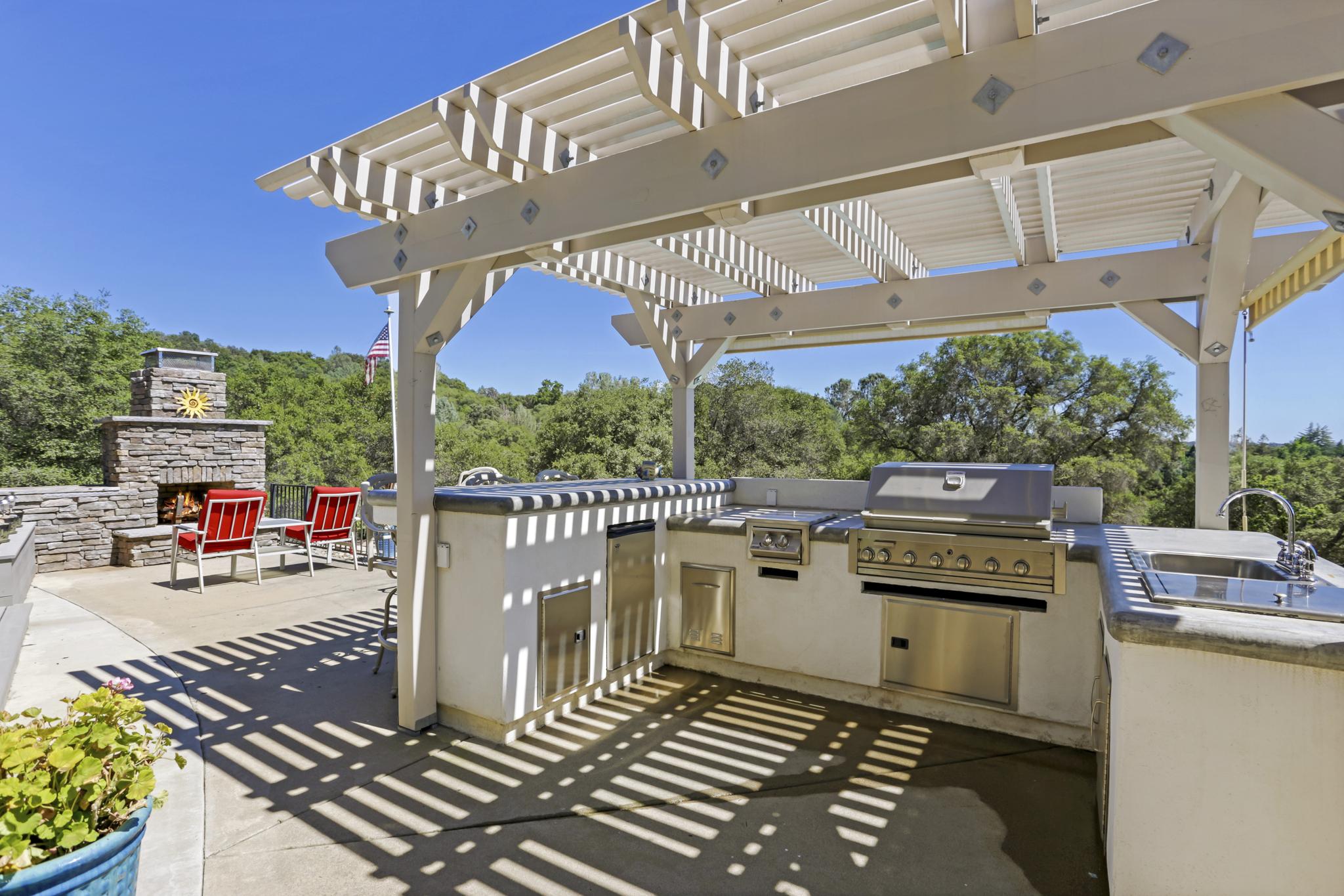 An outdoor barbecue grill with pergola on a sunny day.