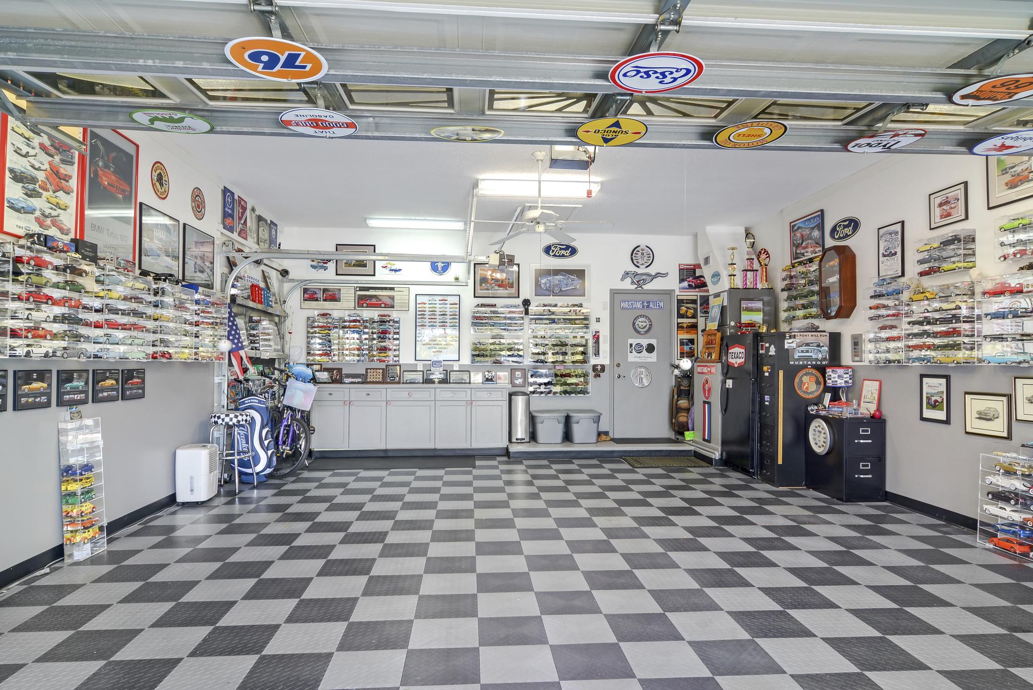 Garage with vintage license plates and checkerboard floor.