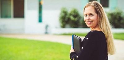 Appraiser holding clipboard in front of house