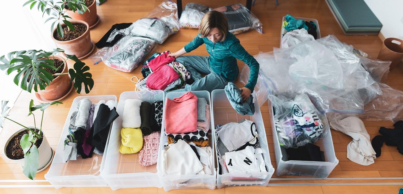 Woman organizes clothes in living room of her home