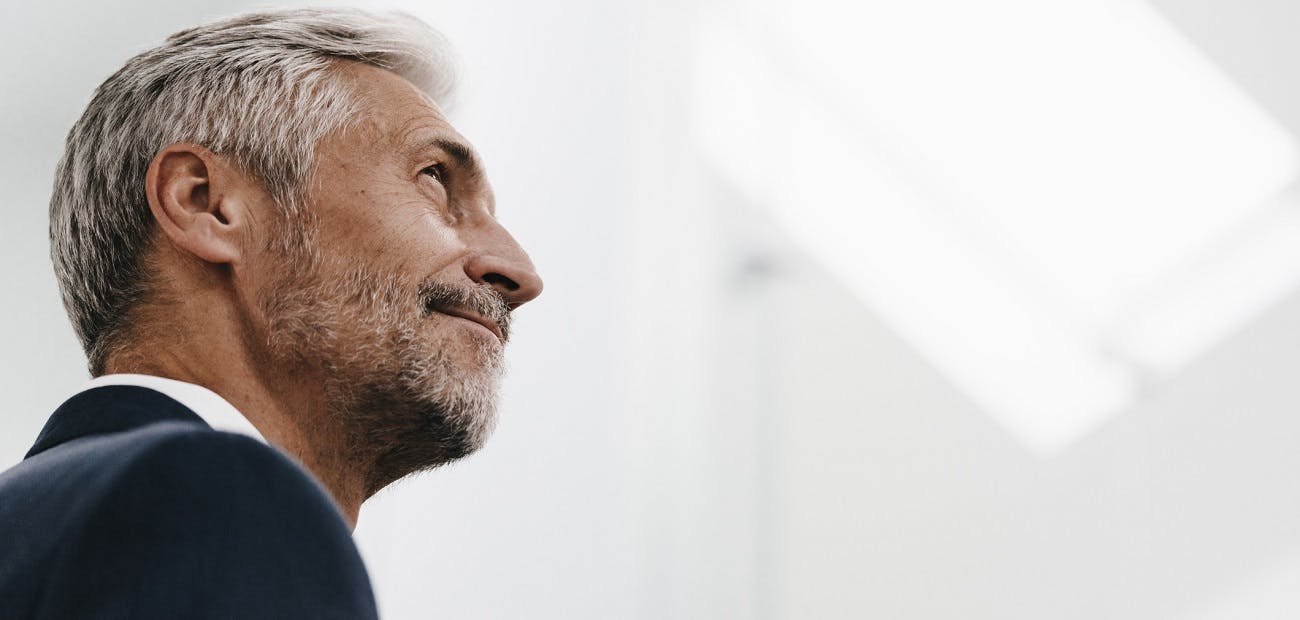 Confident mature businessman looking up