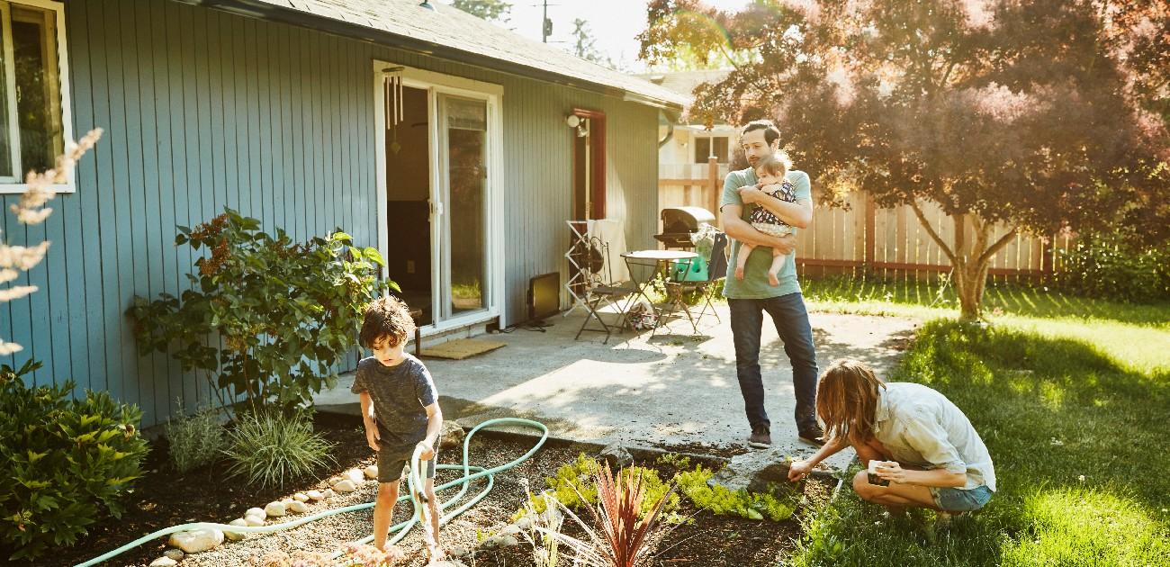 A family in their backyard of a new home.