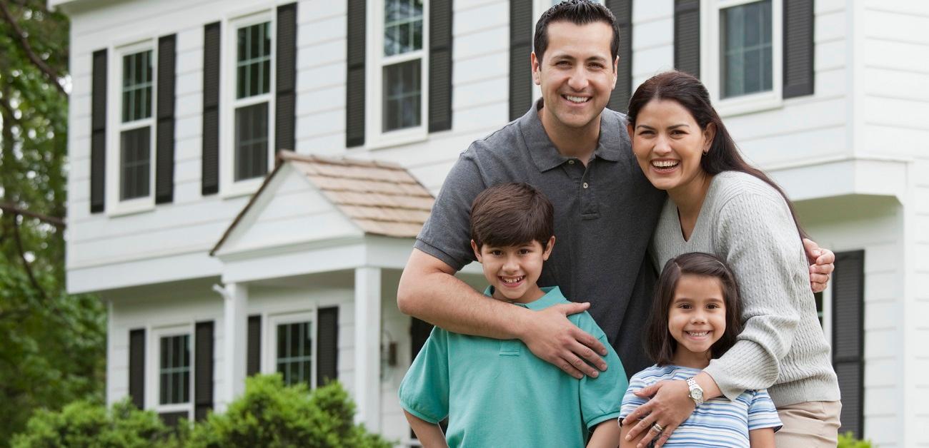 Hispanic family posing in front of house