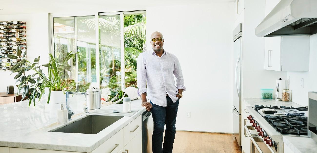 A man stands in a brightly lit kitchen of his new home.