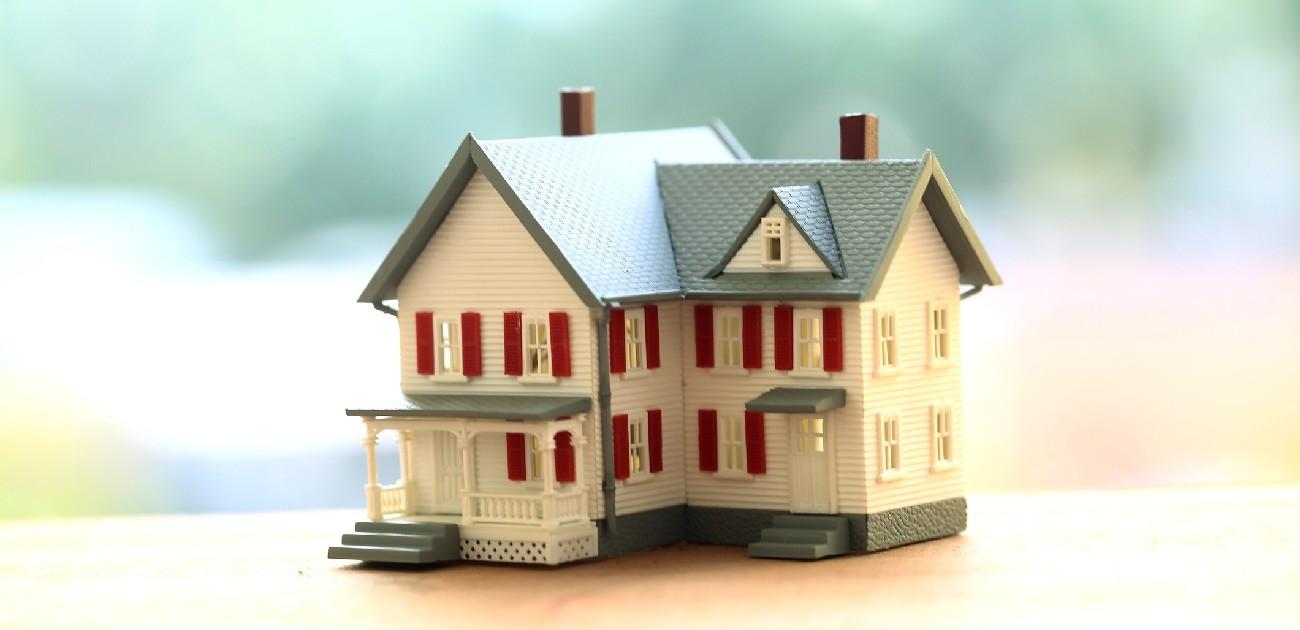 A picture of a house miniature resting on a table with a blurred background.