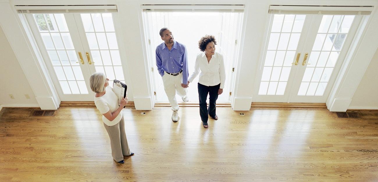 real estate agent showing couple interior of home