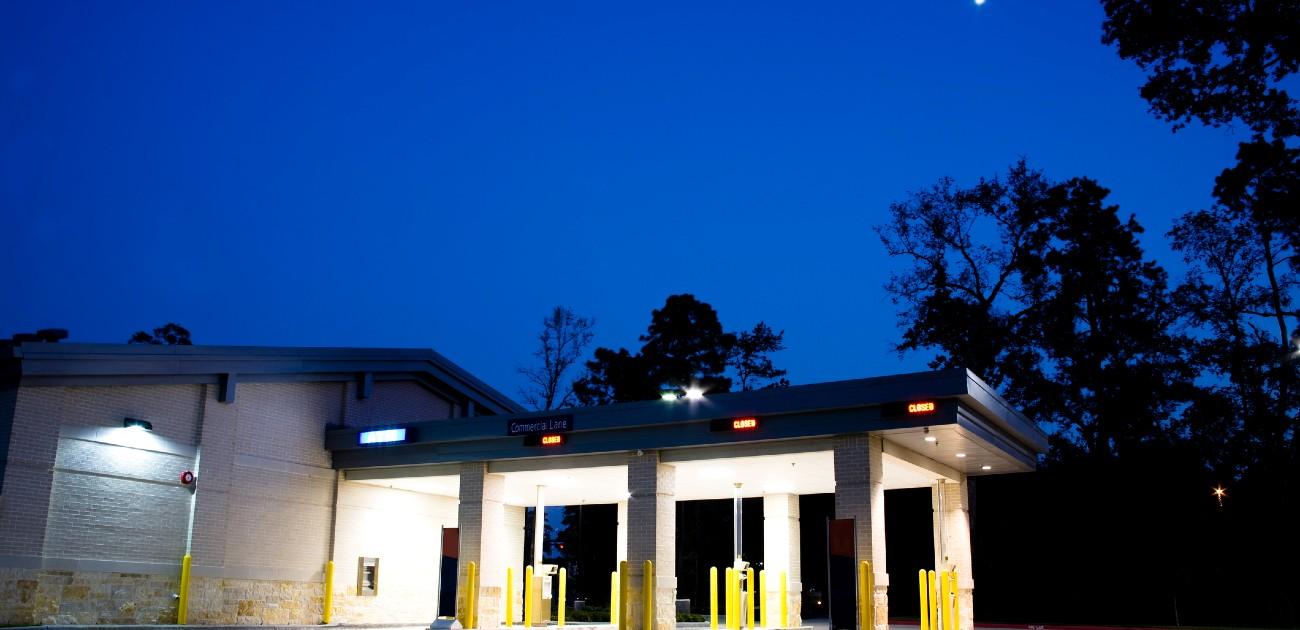 A picture of a commercial property with a set of drive-thru lanes under a roof.