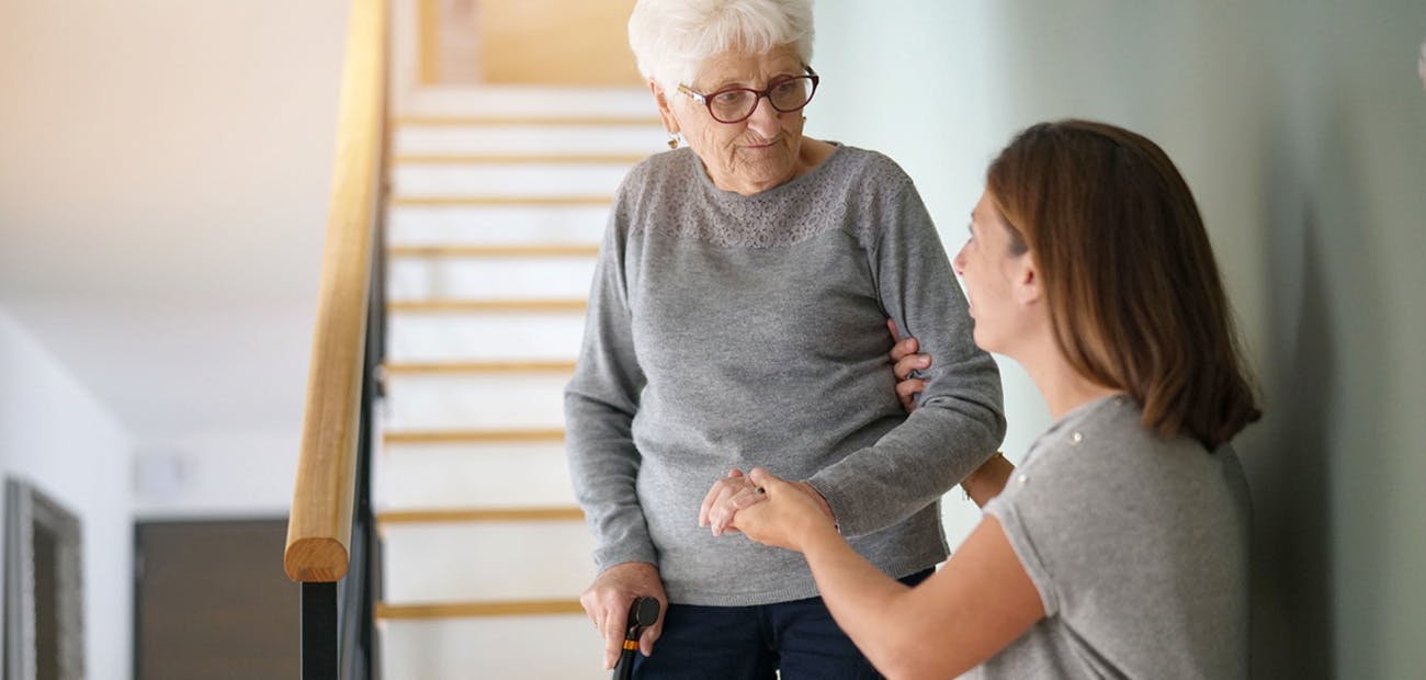 elderly woman being helped down stairs