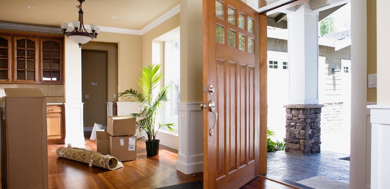 A picture of a home's interior facing the front door which is open showing the outside.