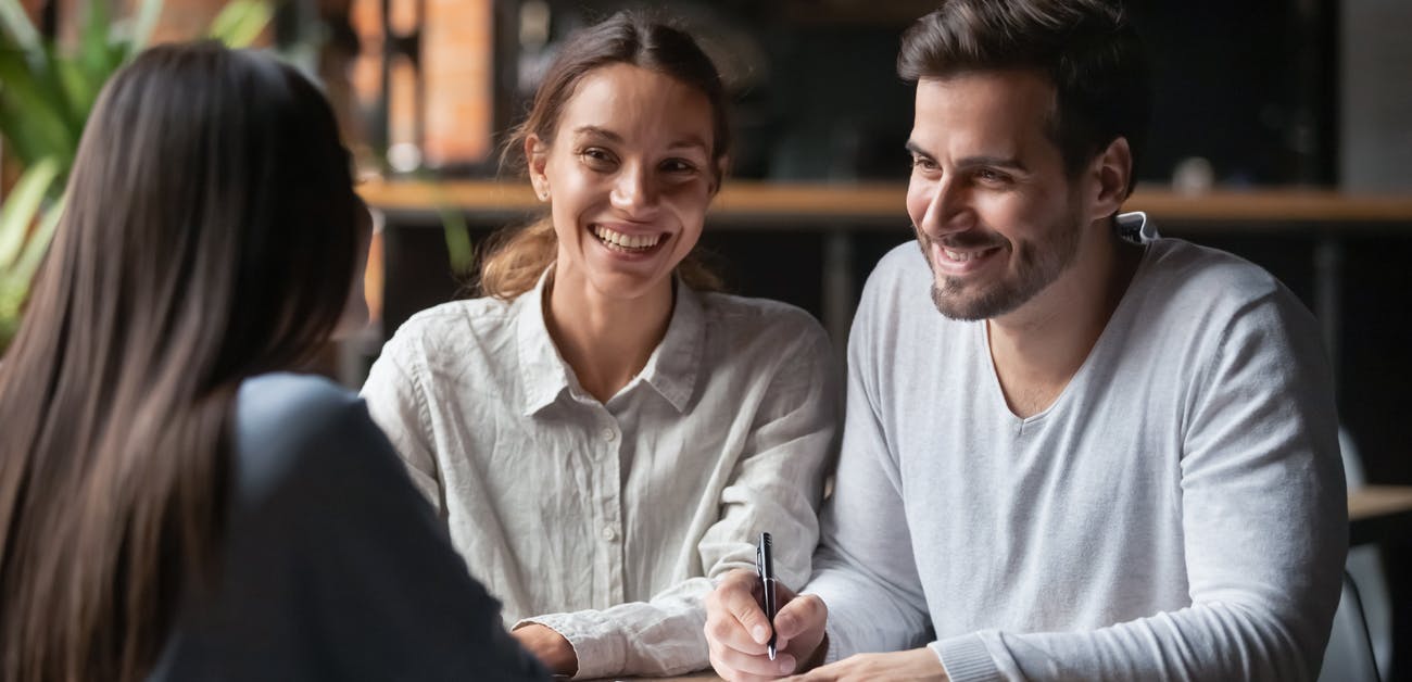 Couple signing paperwork with agent