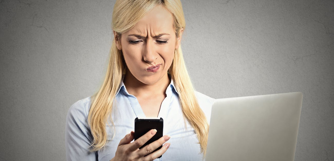 Displeased woman reading text message on phone