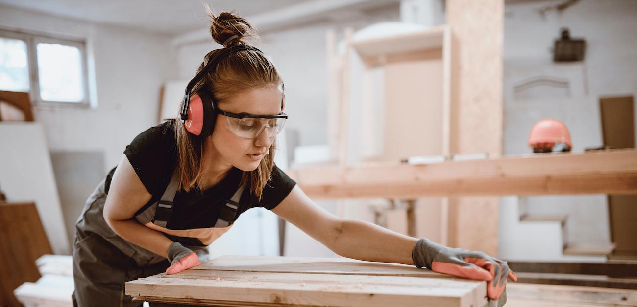 Woman cutting boards for basement renovation