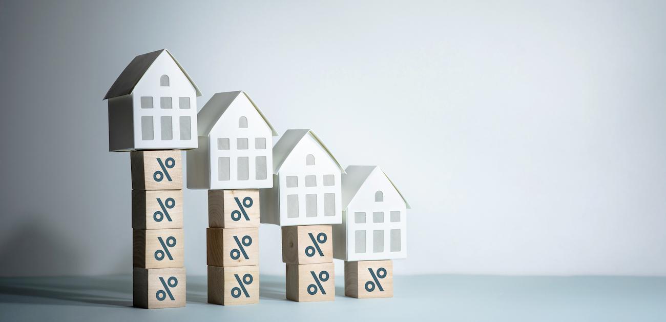 Model houses on top of boxes with percentage signs depicting mortgage rates