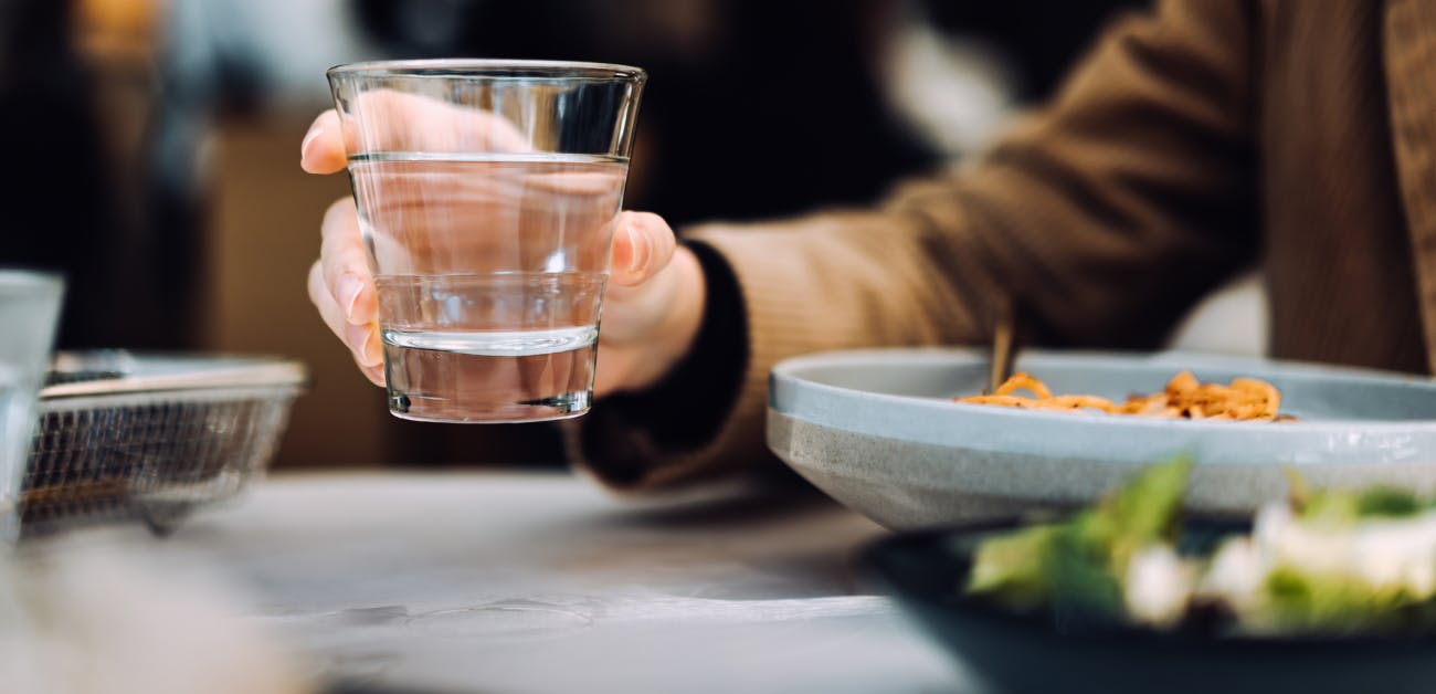 Woman holding glass of water