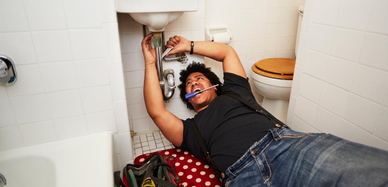 A man repairing a bathroom sink's P-trap