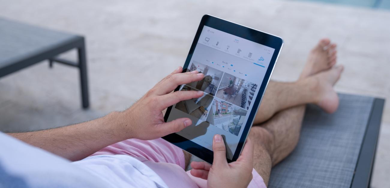 A man watching surveillance cameras on a tablet