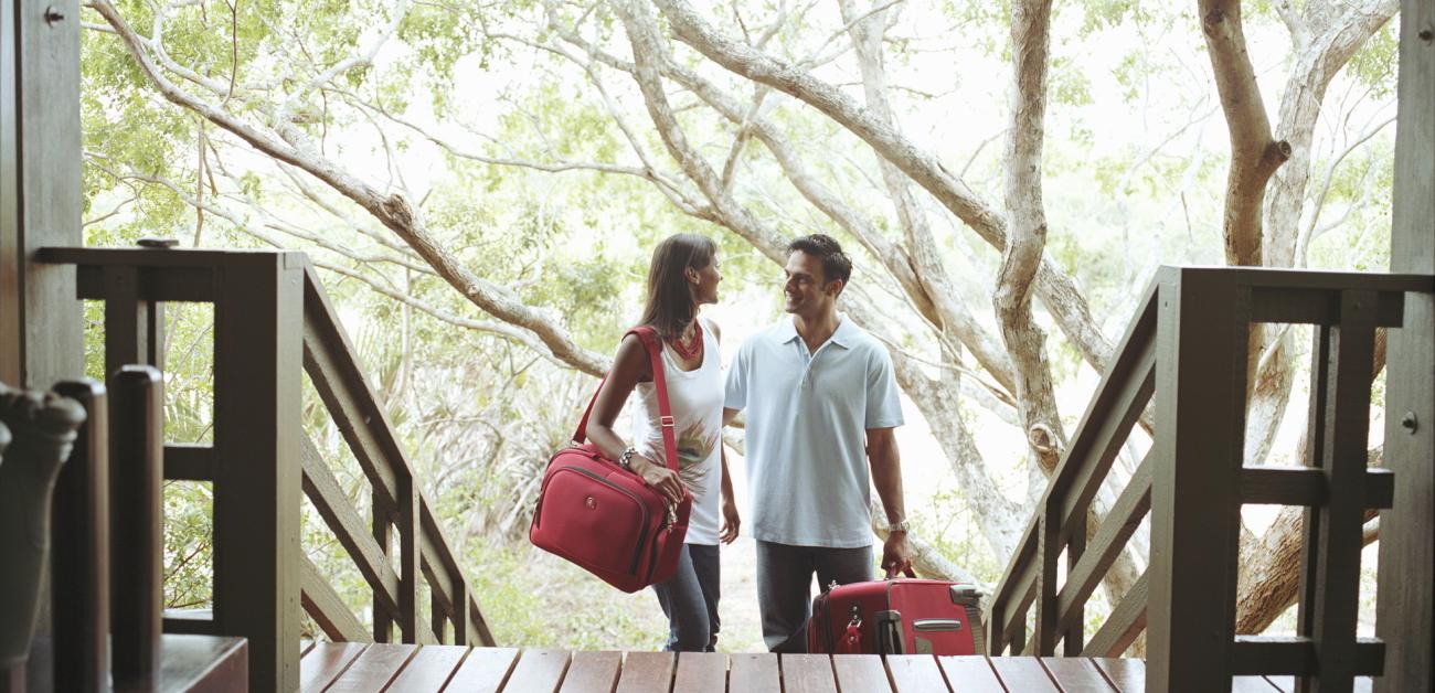 A couple ascending the stairs to a porch in a country setting