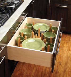 Drawer with pegs to organize dishes.