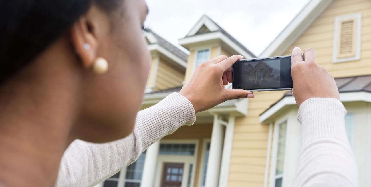 wWoman taking photo of new home