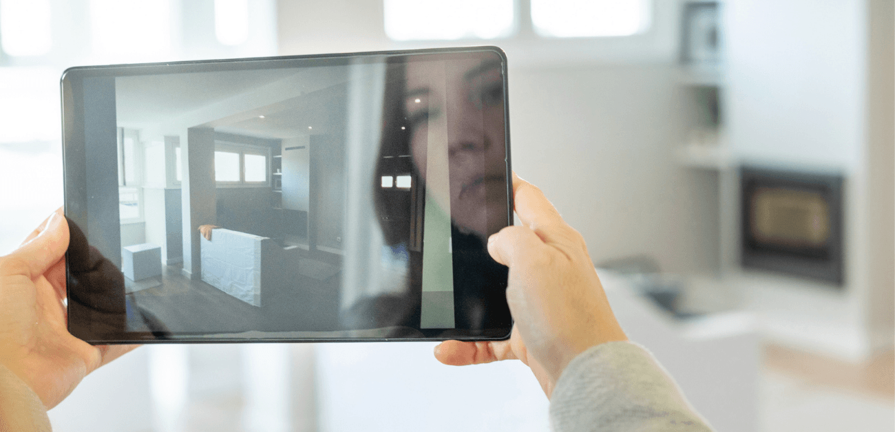 Hands holding a tablet taking a photo of a room