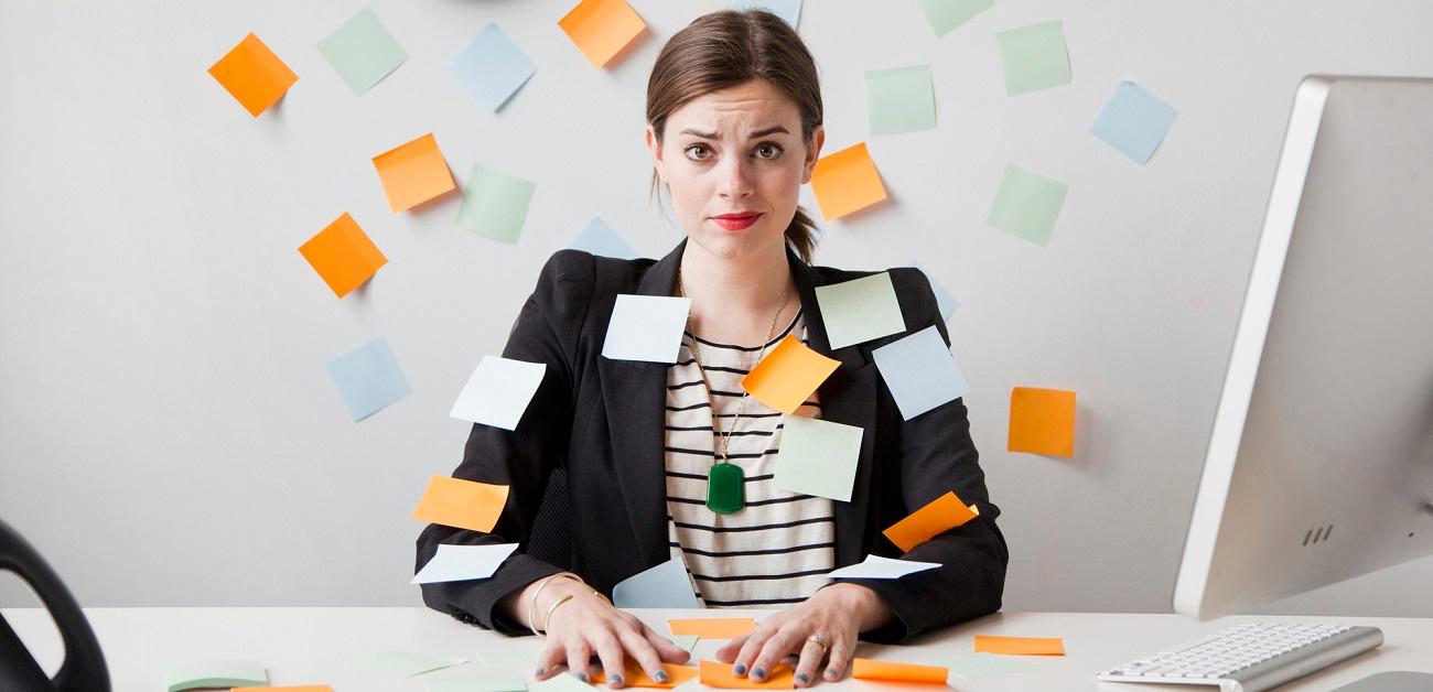 young woman working in office covered with adhesive notes