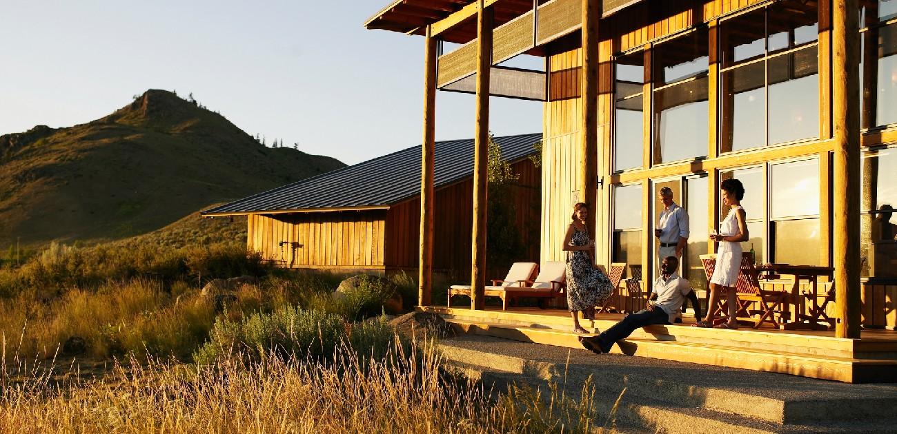 A picture of a family relaxing on the front porch of a vacation home.