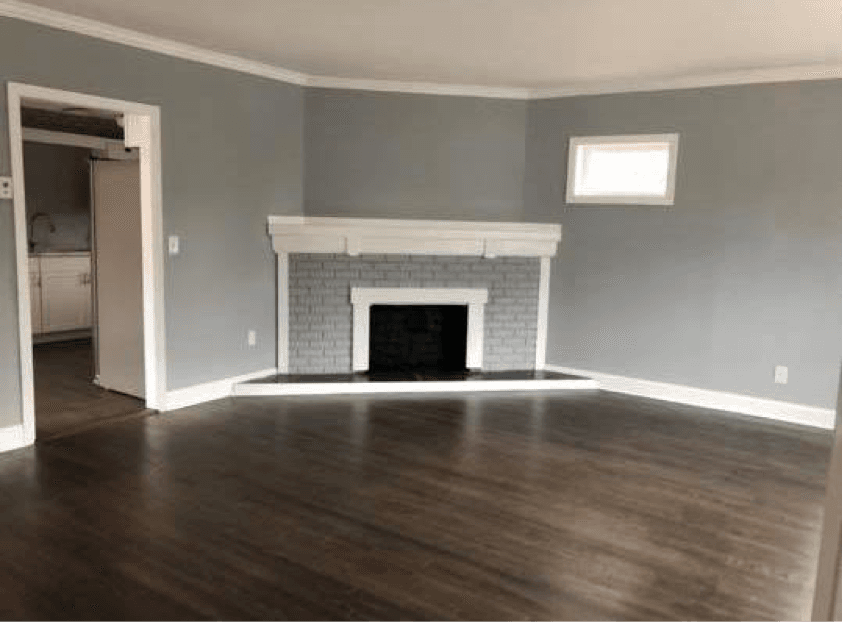 an empty living room with a fireplace