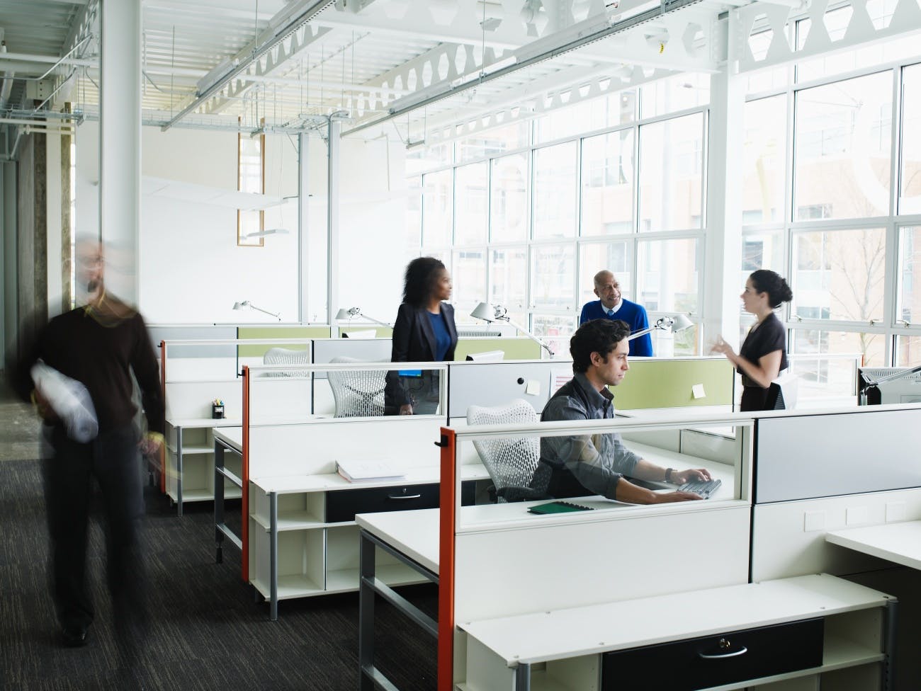 Colleagues talking at workstations