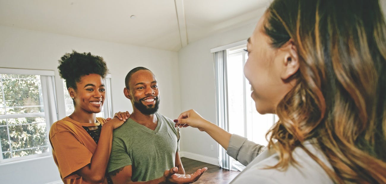 A first-time buyer couple receives keys to their first home