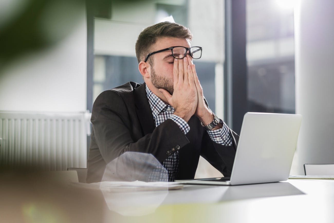 Stressed out business man sitting at laptop in office 